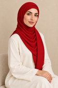 Model wearing a Classic Red modal hijab in a seated pose